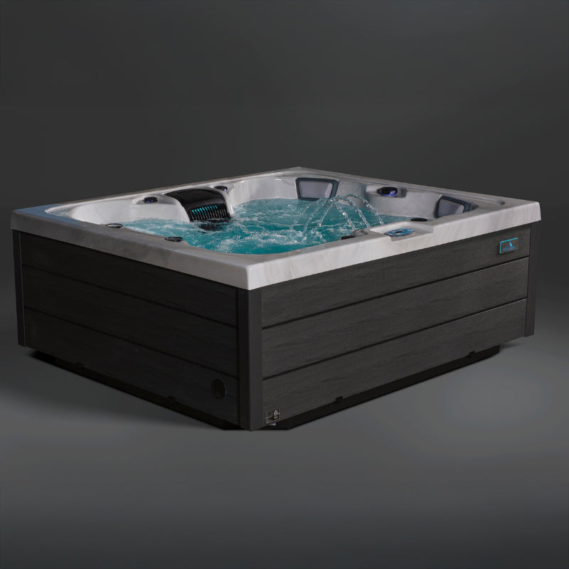 Luxury Aurora hot tub shown filled with water featuring illuminated jets and dark exterior panels.