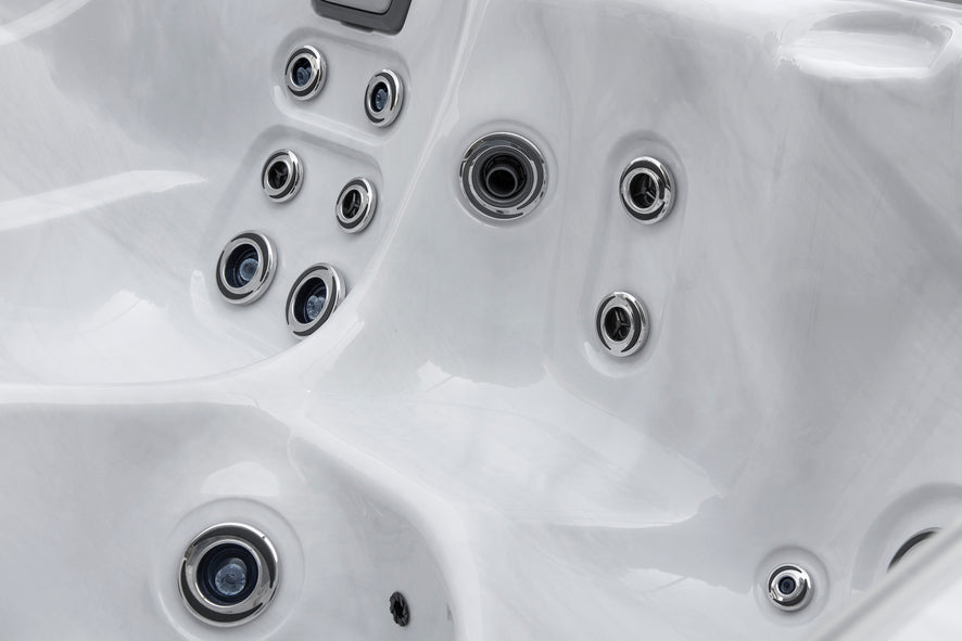 Close-up view of multiple hydrotherapy jets inside a white acrylic Fjord spa seat.