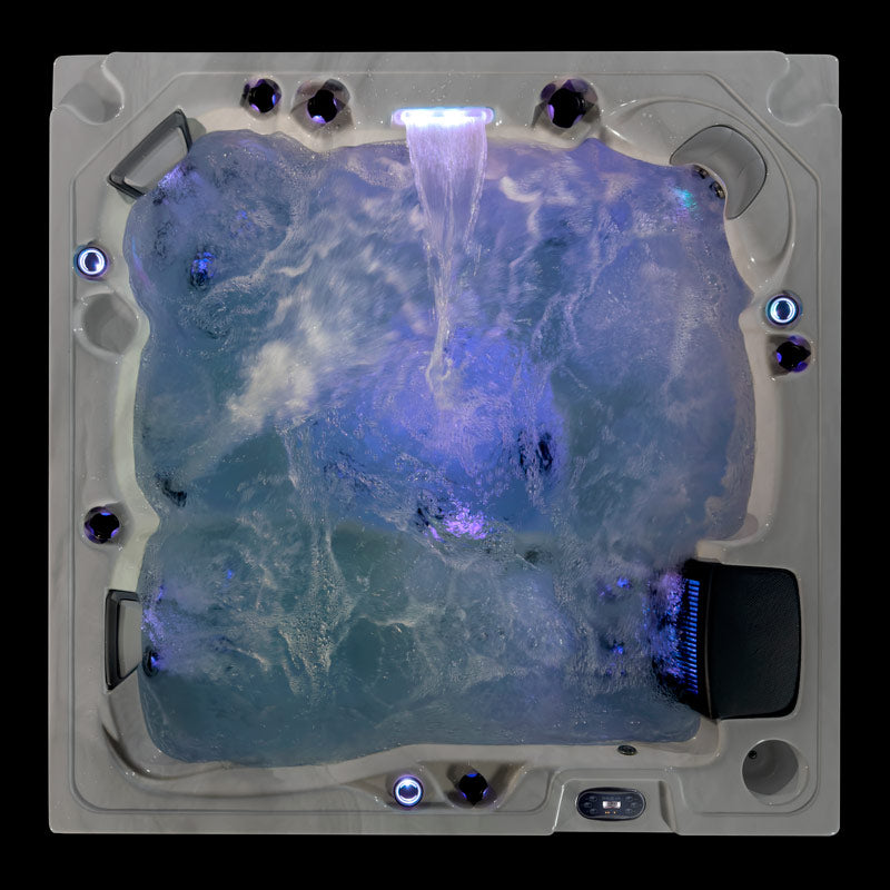 Fjord hot tub top view with cascading waterfall and blue LED lighting during active jet operation.
