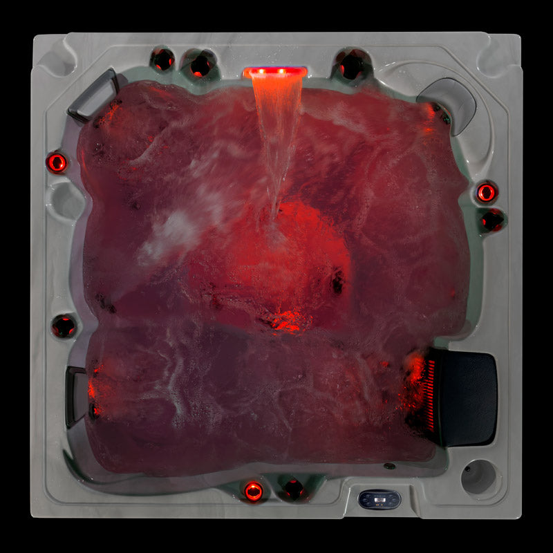 Top-down photo of the Fjord hot tub with red LED lighting and waterfall running over bubbling water.
