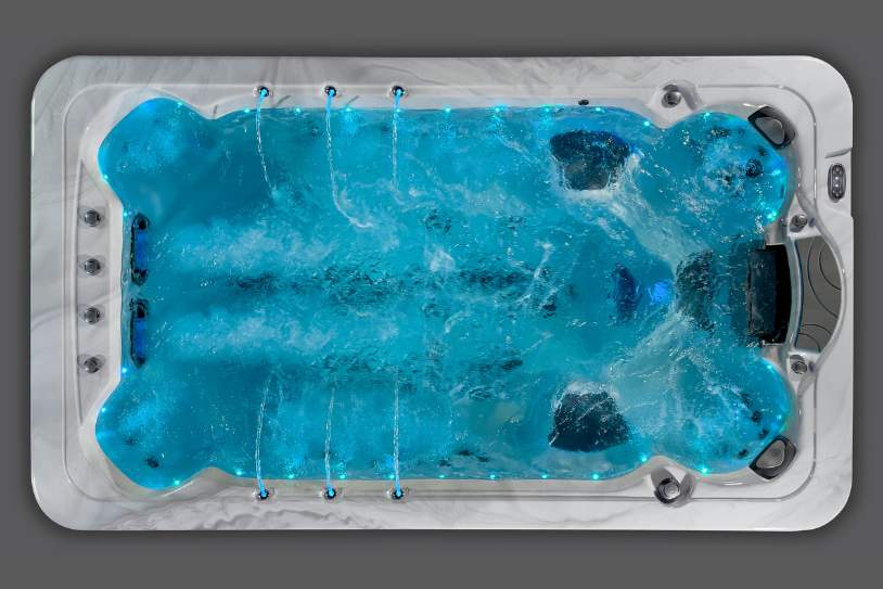 Top view of the Fossa-3B swim spa illuminated with blue LED lighting and active water jets.