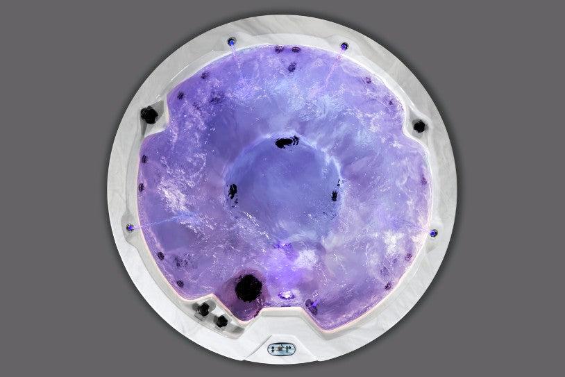 Overhead photo of the Cyclone 1 hot tub glowing with purple LED lighting and active water jets.