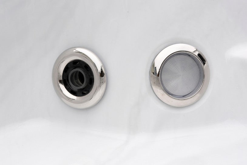Close-up image of a Cyclone 1 spa jet and LED light set into the white acrylic shell.