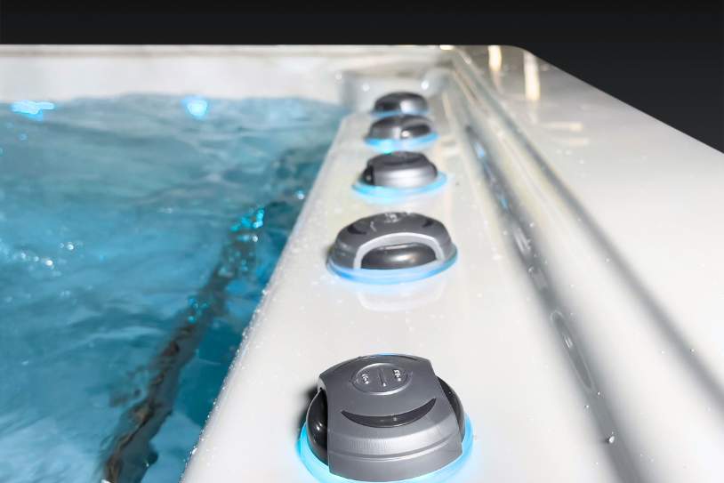 Close-up of the Icelandic swim spa air and water jet dials along the spa edge with illuminated rings.