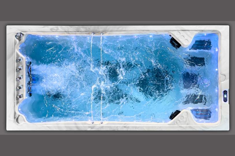 Top-down view of a swim spa with strong water turbulence during operation.