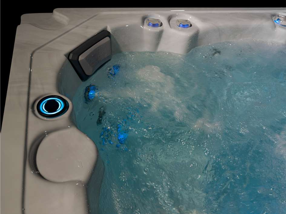 Oasis hot tub corner seat with blue LED lighting and bubbling hydrotherapy jets.
