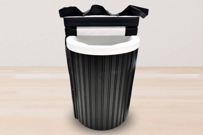 Studio image of a black plunge tub with the lid open, exposing the white interior.