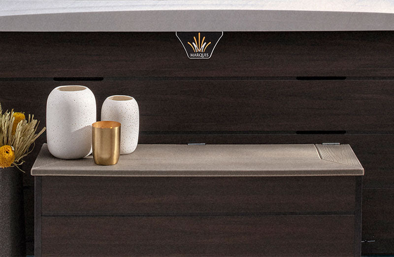 Crown Environments spa storage bench with decorative vases beside the spa cabinet.