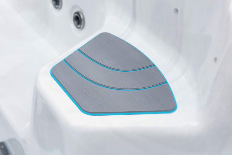 Close-up of the Fossa-3B swim spa’s corner non-slip step with textured blue-trimmed surface.