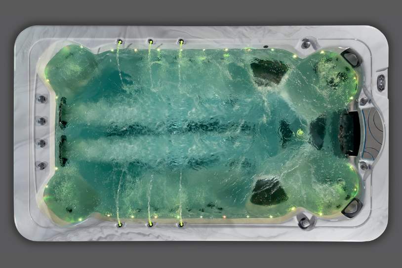 Top-down photo of the Fossa-3B swim spa during a green light cycle with multiple jets in motion.