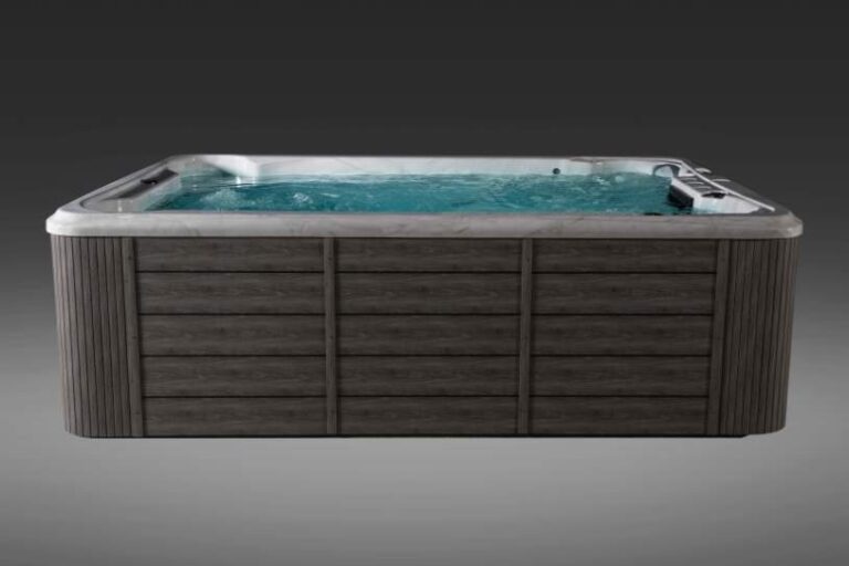 Fossa PP side view of Icelandic swim spa filled with water and dark exterior paneling.
