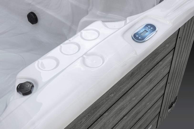 Fossa PP close-up of the Icelandic Swim Spa control panel and cup holders on the white acrylic shell.