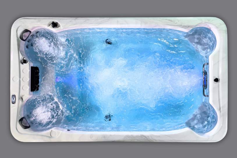 Fossa PP overhead view of the Icelandic Swim Spa illuminated in blue with calm water and seating layout.