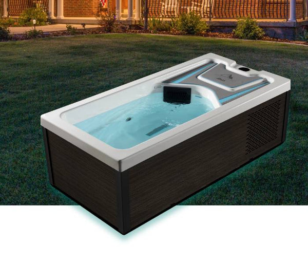 Icelandic Bath filled with water and illuminated outdoors on a lawn near a porch at dusk.