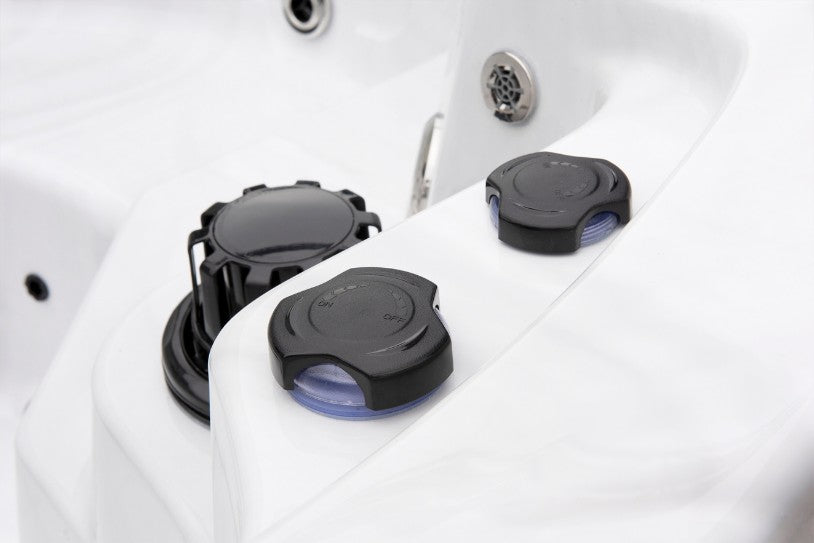Cyclone 1 hot tub air control caps and waterflow controls positioned along the spa’s edge.