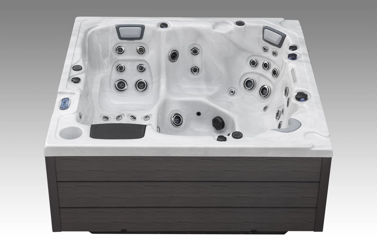 Front-facing view of the Icelandic Wellness Fjord hot tub with reclining seats, control panel, and massage jets.