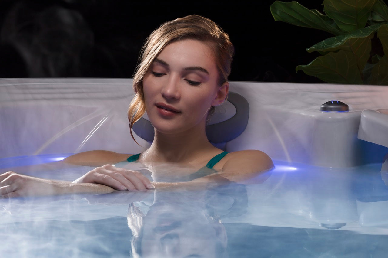 Woman relaxing in a MicroSilk spa with warm steam rising from the water.