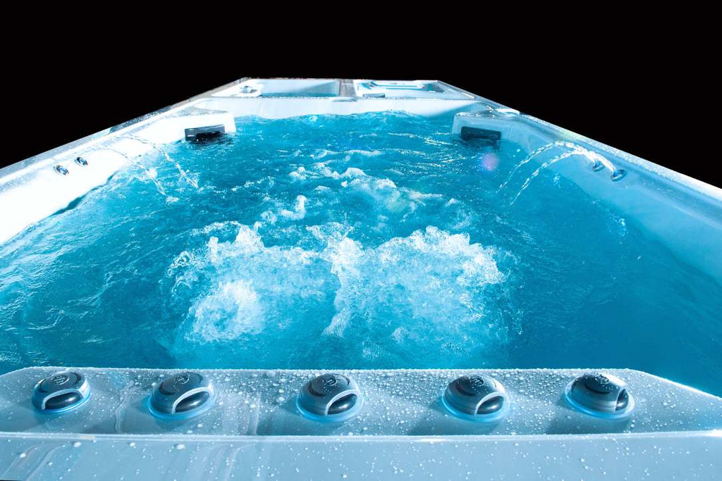 Front view of the Triathlon 3-in-1 swim spa swim zone showing powerful jets and bubbling water.