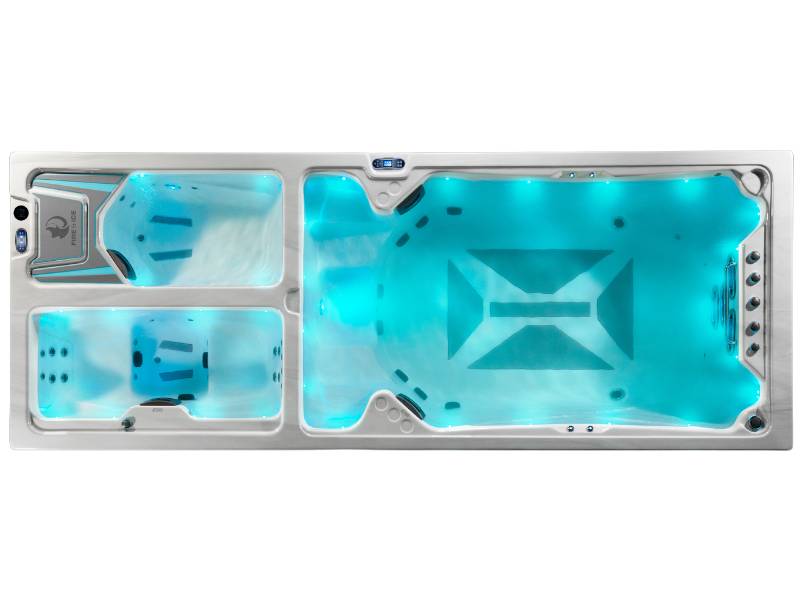Top-down view of the Triathlon 3-in-1 swim spa displaying the illuminated swim zone, hot tub seats, and ice tub.